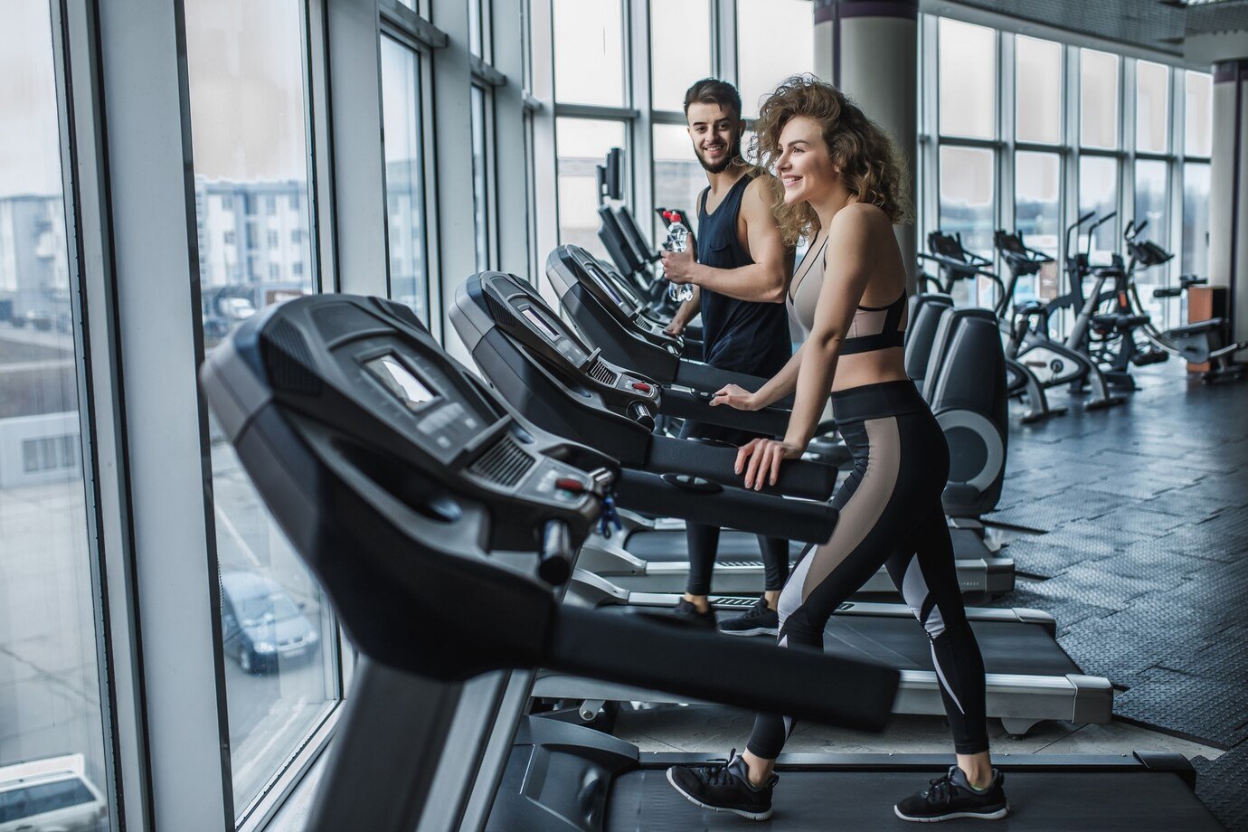 portrait-young-sports-couple-making-cardio-workout-modern-gym_496169-2712
